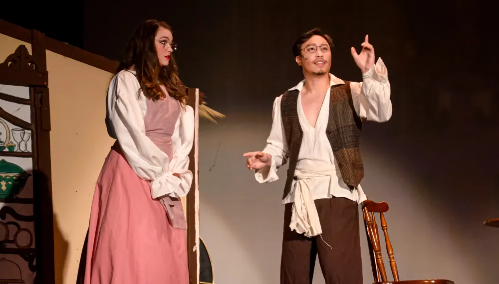 Khoa on stage in costume next to another actor